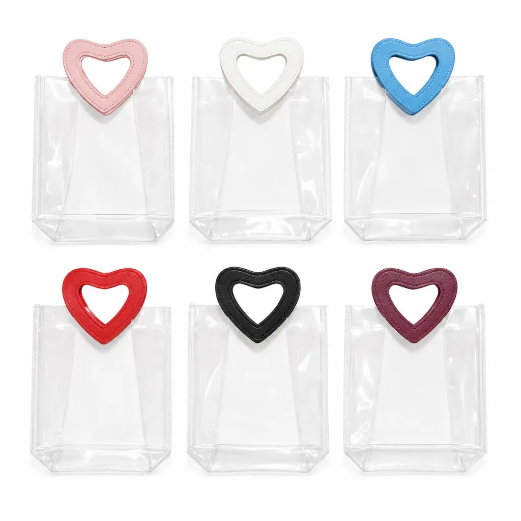 BOLSAS DE PVC TRANSPARENTES CON MANIJAS DE CORAZON COLORES SURTIDOS 20CM*18CM